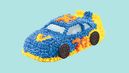 A colorful cake with a toy car on top.