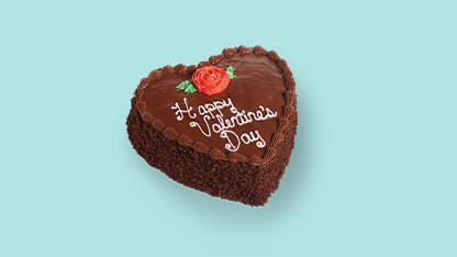 Valentine's Day cake with chocolate frosting and a red rose on top.