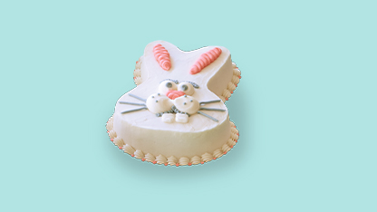 Elegant cake shaped like a cat. White frosting and pink accents adorn the feline figure. It sits on a vibrant blue background, adding a pop of color to the scene.
